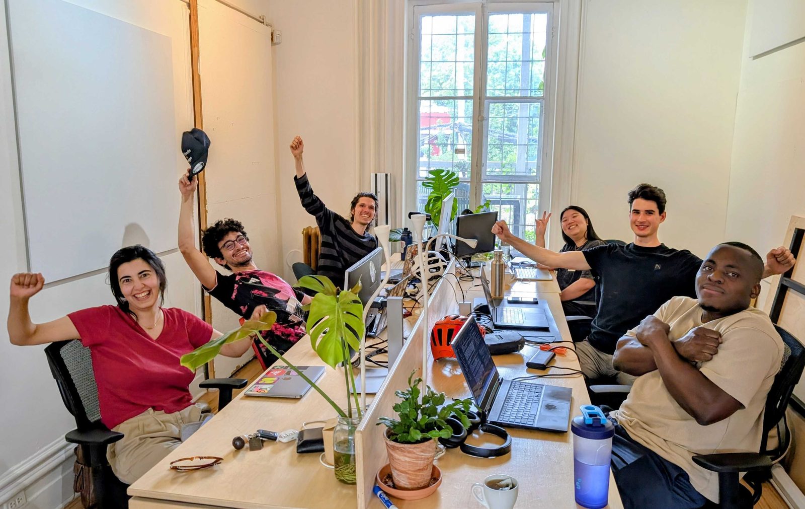 L’équipe de Tara Research aux postes de travail partagés d’Ω Labs, plantes et grande fenêtre derrière elle